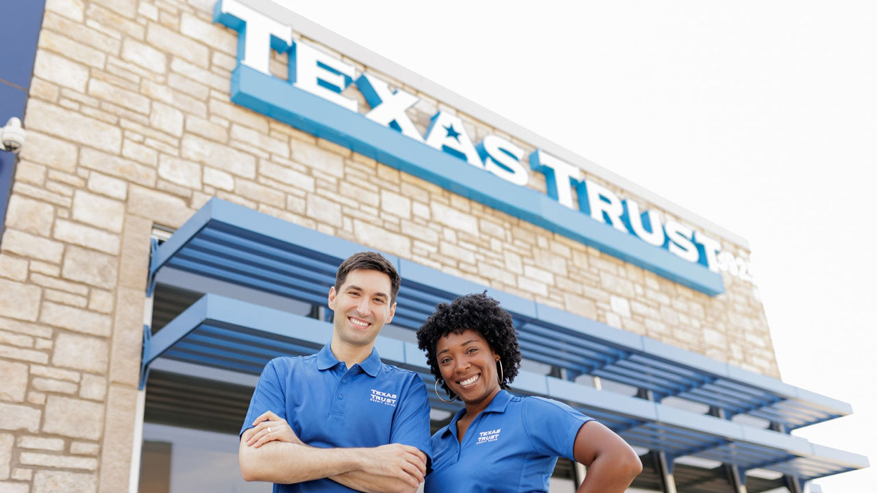 Two Employees in front of a Texas Trust Branch