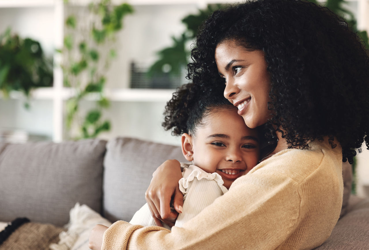 Mother and daughter embracing on a couch